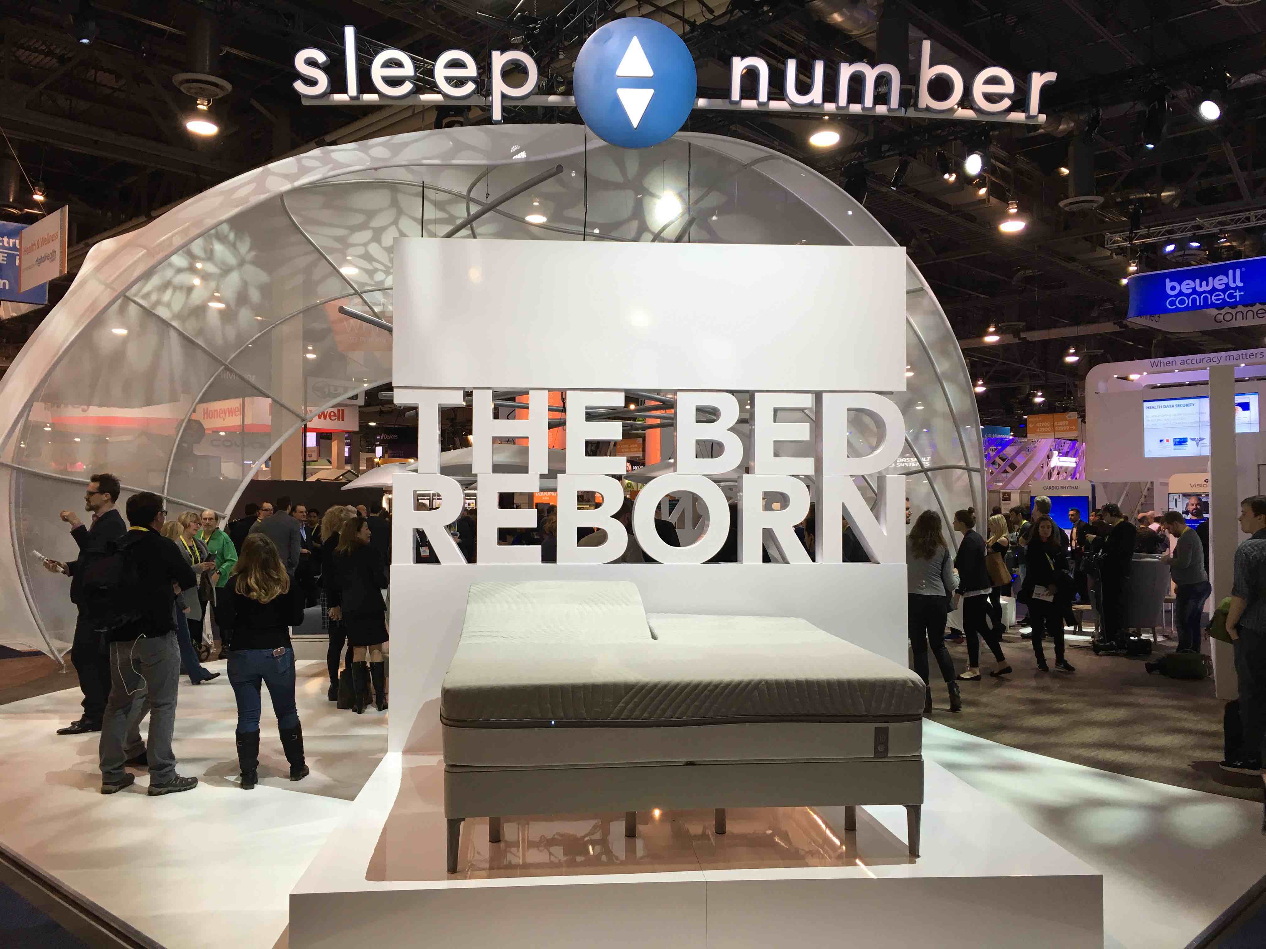 Smart bed in front of a sign reading "The Bed Reborn" at CES 2017 trade show